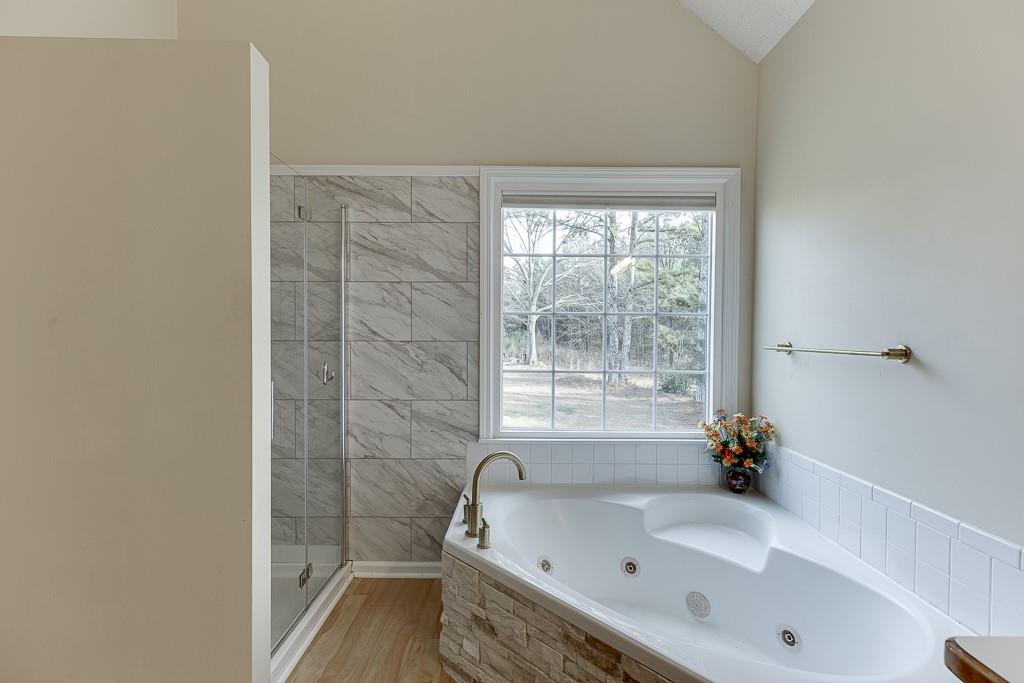 1262 Bowman Road Lawrenceville, GA 30045 - Photo 21 of 32 a bathroom with a tub and a shower
