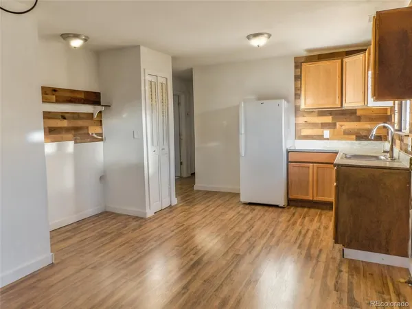 a view of a kitchen with wooden floor electronic appliances and windows
