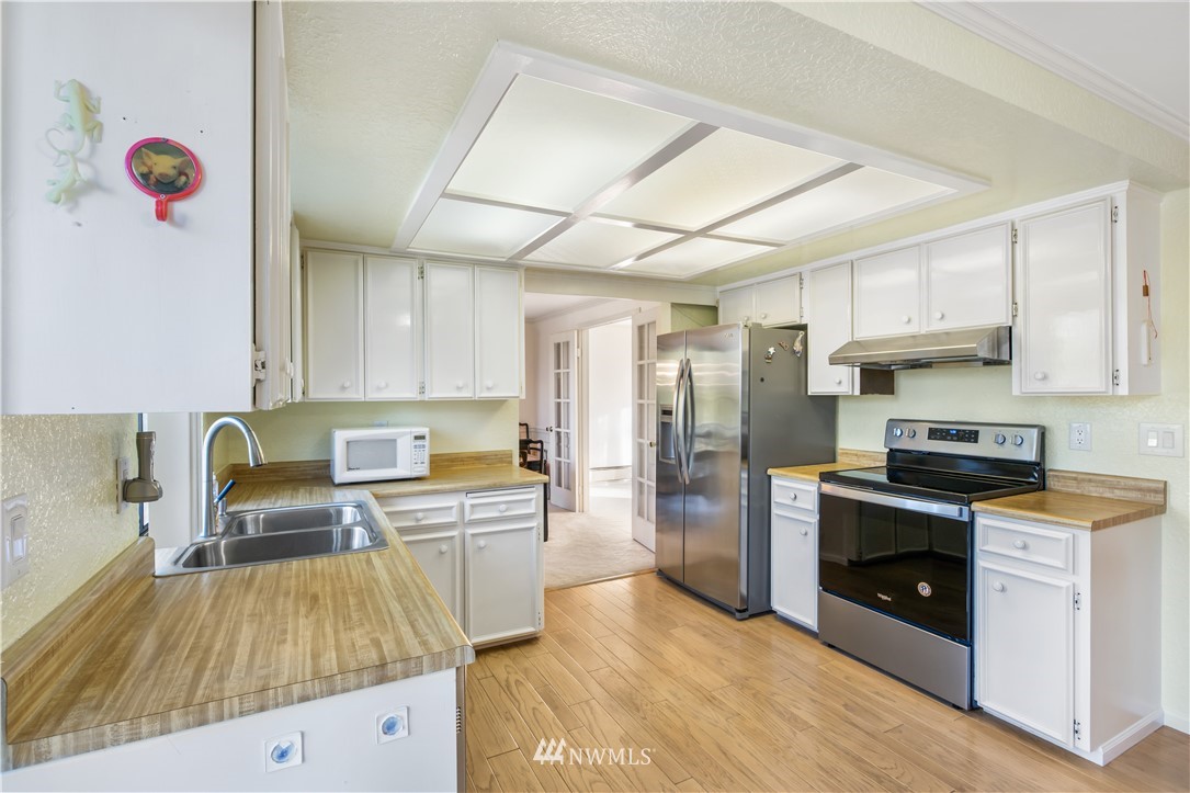 2012 Jones Circle Southeast Renton, WA 98055 - Photo 7 of 25 a kitchen with stainless steel appliances granite countertop a stove a sink and a refrigerator
