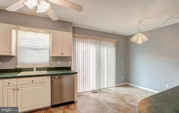 a kitchen with granite countertop white cabinets and white appliances