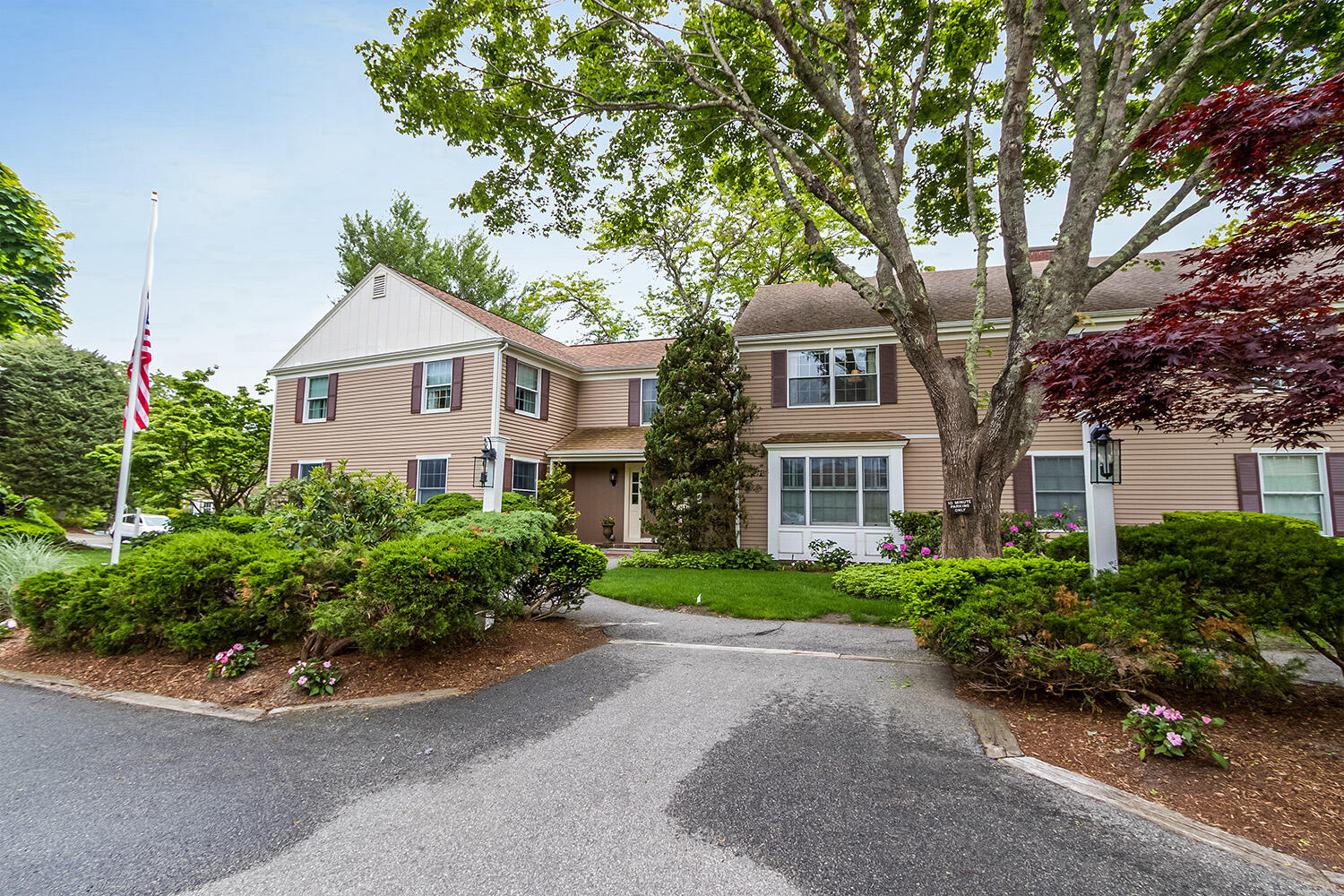 39 Tower Hill Road, Unit 4C Osterville, MA 02655 - Photo 2 of 23 a front view of a house with a yard and a garage