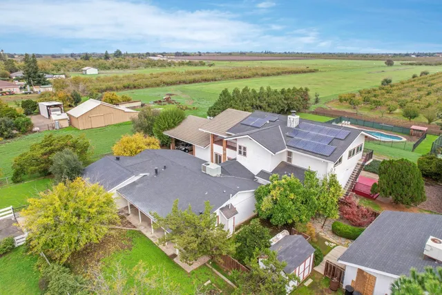an aerial view of residential houses with outdoor space and a lake view