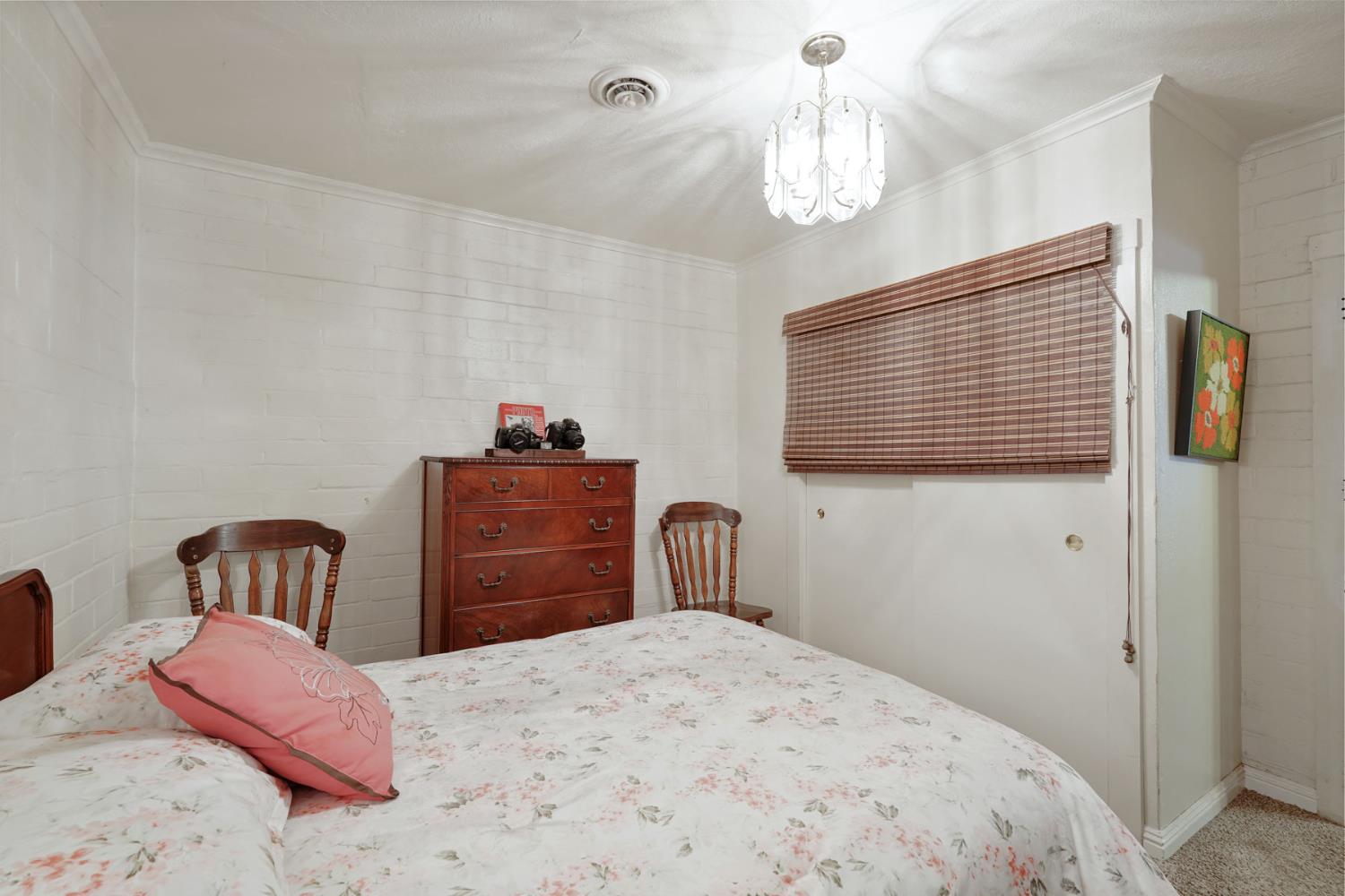 5766 Alpine Road Stockton, CA 95215 - Photo 36 of 99 a bedroom with a bed and a chandelier