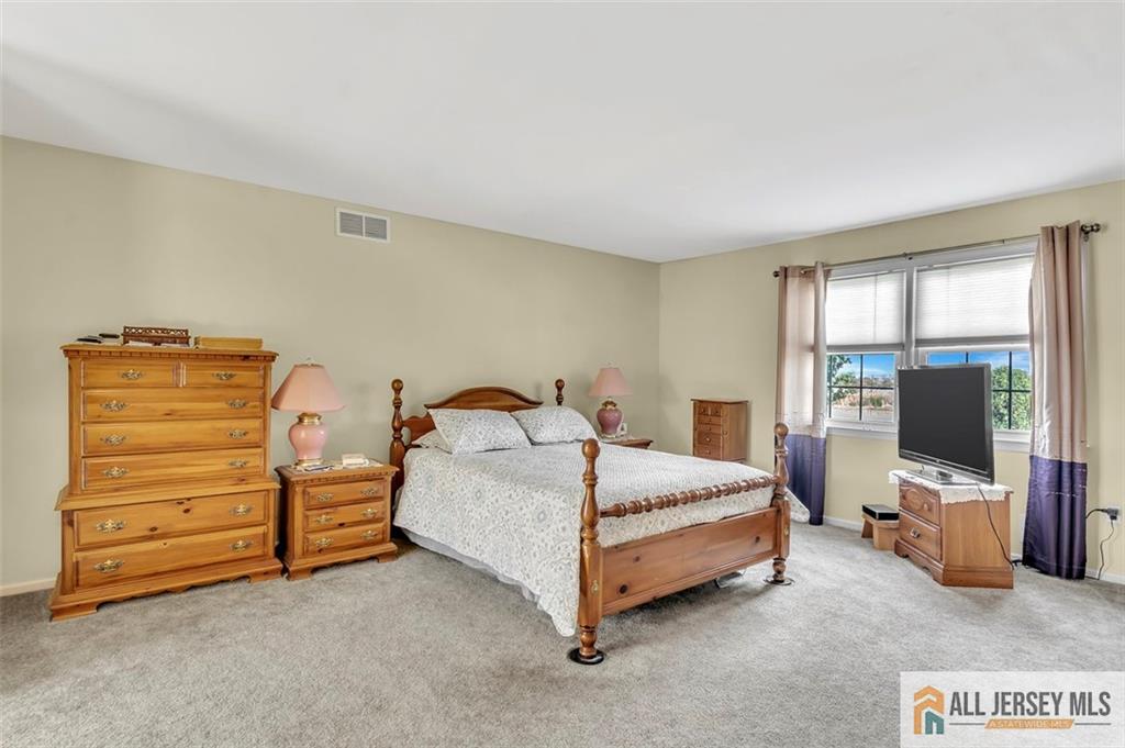 93 Remmey Street Fords, NJ 08863 - Photo 18 of 27 a bedroom with a bed and flat tv screen on dresser