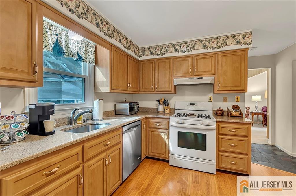 93 Remmey Street Fords, NJ 08863 - Photo 9 of 27 a kitchen with stainless steel appliances granite countertop a stove a sink and white cabinets