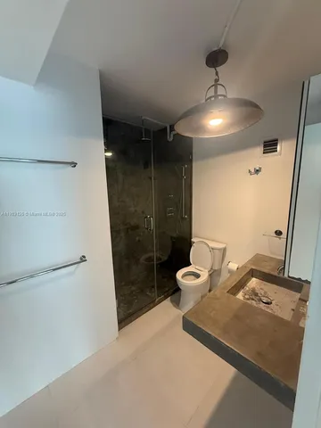 a bathroom with a double vanity sink toilet and shower