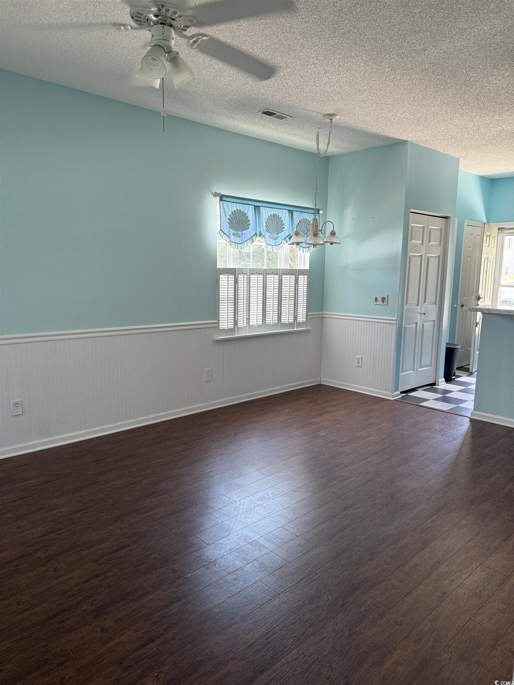 4206 Sweetwater Boulevard Murrells Inlet, SC 29576 - Photo 4 of 10 Empty room with a textured ceiling, a wainscoted w