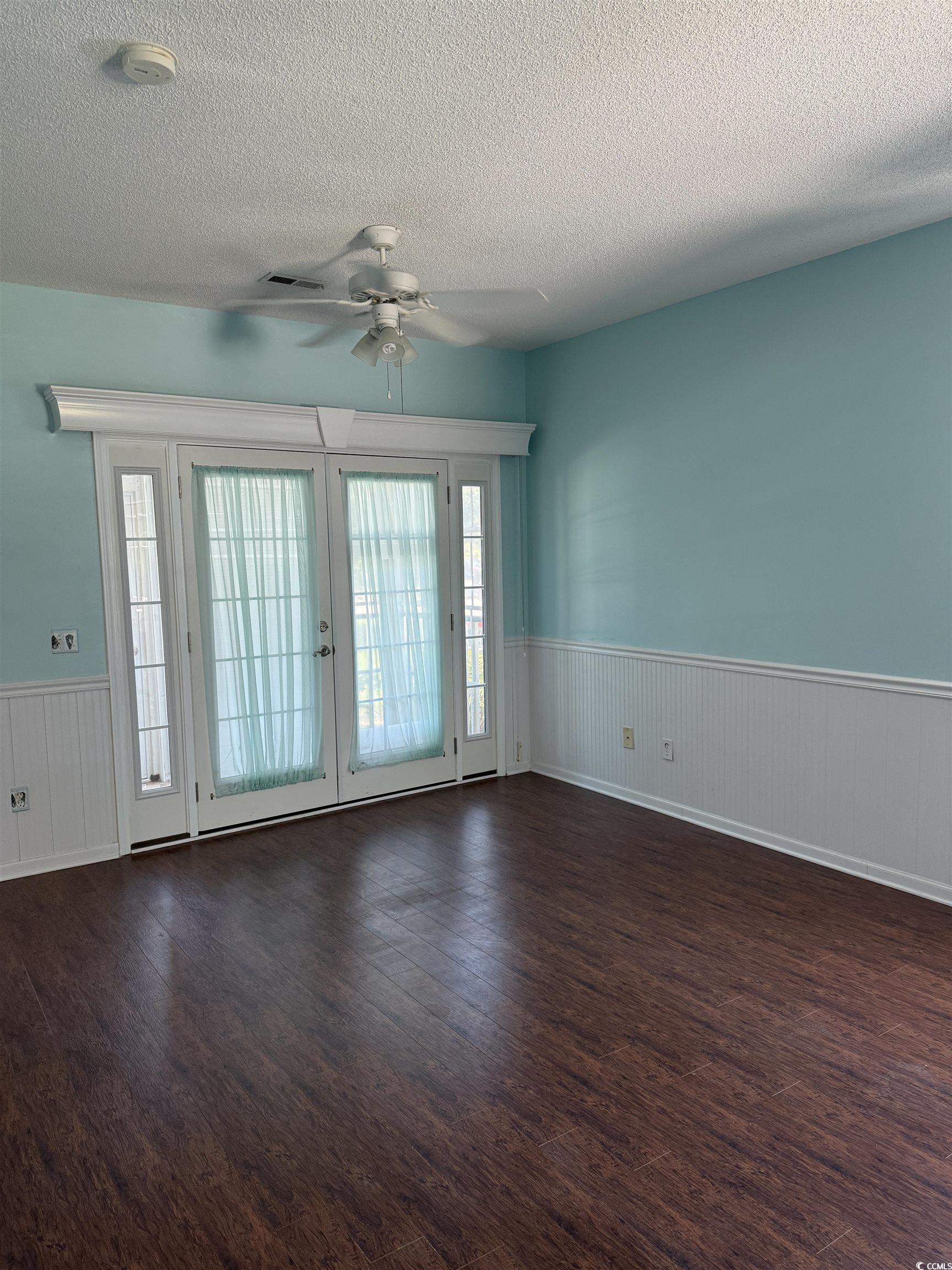 4206 Sweetwater Boulevard Murrells Inlet, SC 29576 - Photo 5 of 10 Spare room featuring a wainscoted wall, a textured