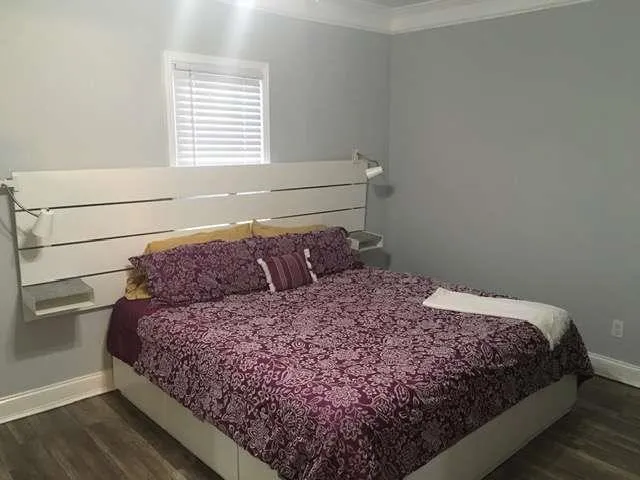a large bed sitting in a bedroom next to a window