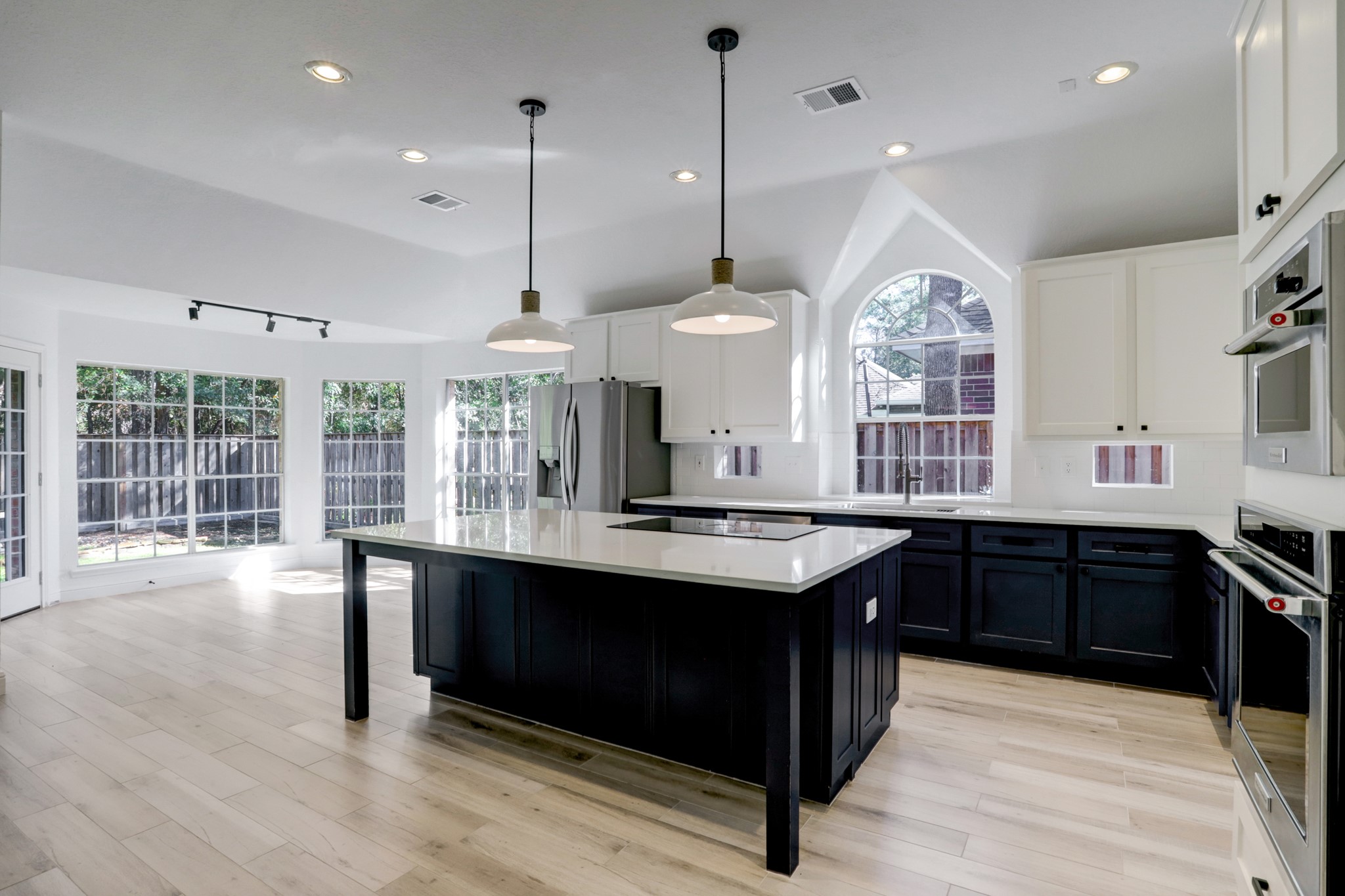 138 Summer Storm Place Spring, TX 77381 - Photo 10 of 20 The bright kitchen features abundant cabinetry, pendant lighting, an island cooktop and distinctive arched windows.