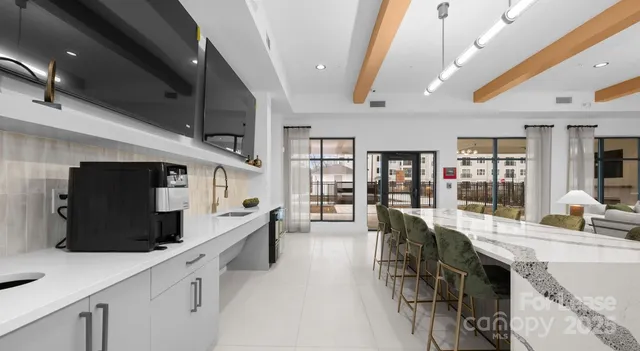 a large white kitchen with lots of counter space and glass door