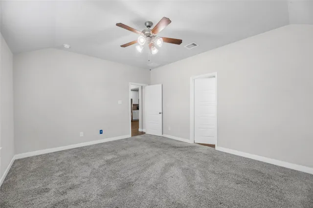 an empty room with closet and fan