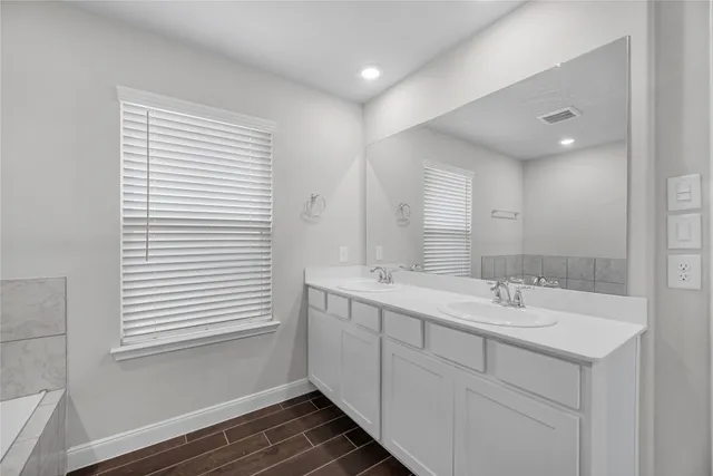 a bathroom with a double vanity sink and a mirror