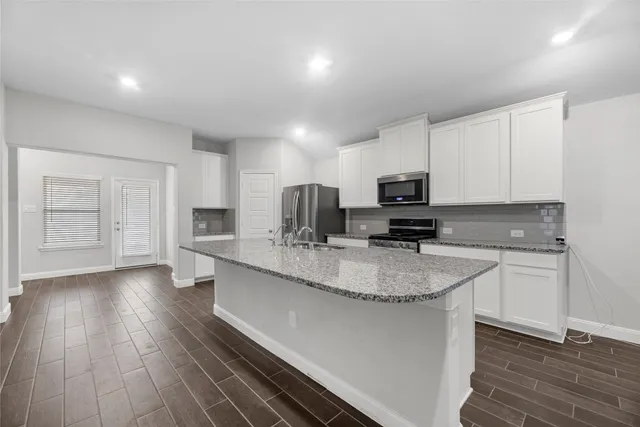 a kitchen with stainless steel appliances granite countertop a sink refrigerator stove and microwave