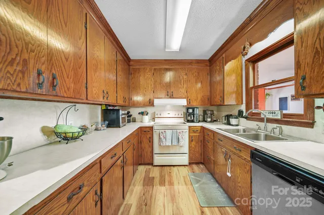 a kitchen with stainless steel appliances granite countertop a sink a stove and cabinets