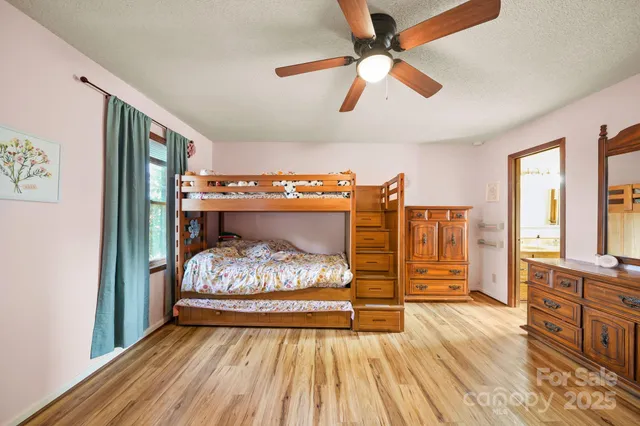 a bedroom with a bed and wooden floor