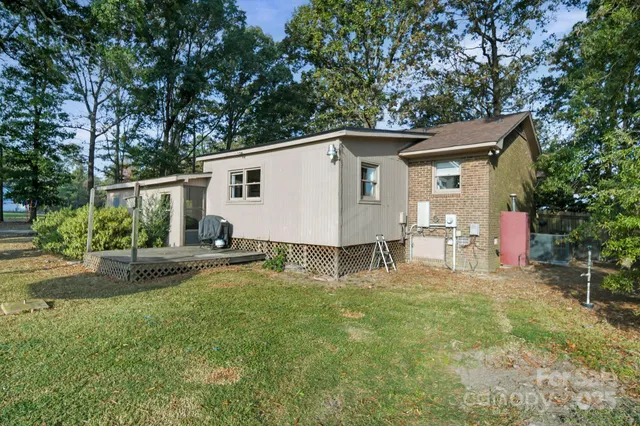 a view of a house with a yard and chairs