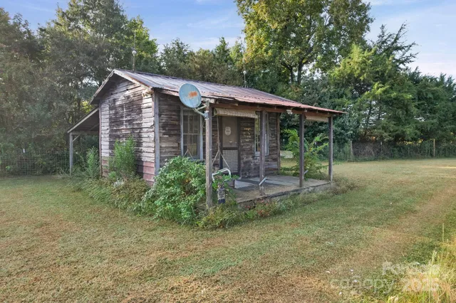 a view of a house with a yard and large tree