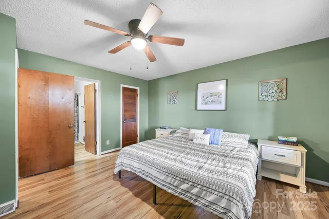 a bedroom with a bed and wooden floor