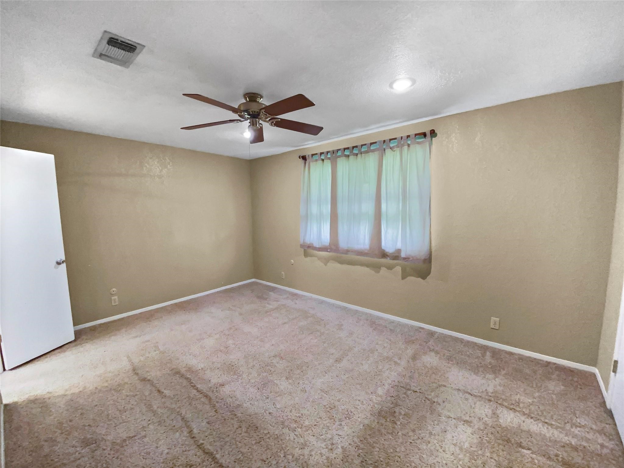 516 Dwyer Street Angleton, TX 77515 - Photo 10 of 18 an empty room with windows and fan