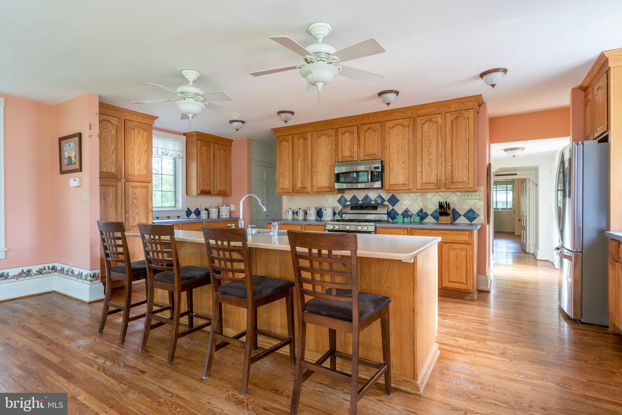301 Midland Avenue Wayne, PA 19087 - Photo 16 of 63 a kitchen with stainless steel appliances kitchen island granite countertop a table chairs and a refrigerator