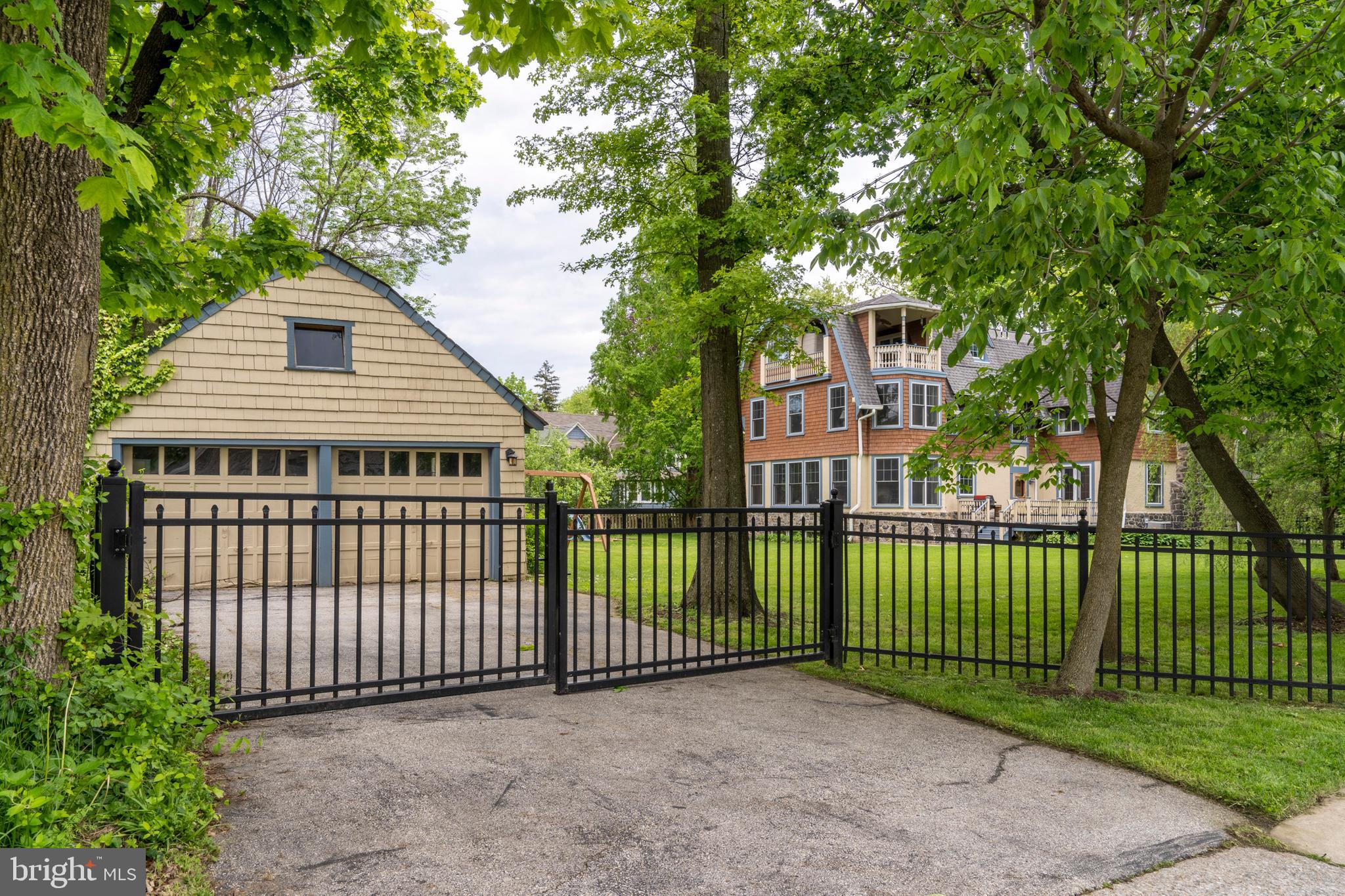 301 Midland Avenue Wayne, PA 19087 - Photo 56 of 63 a view of a brick house in front of a yard with plants and large trees