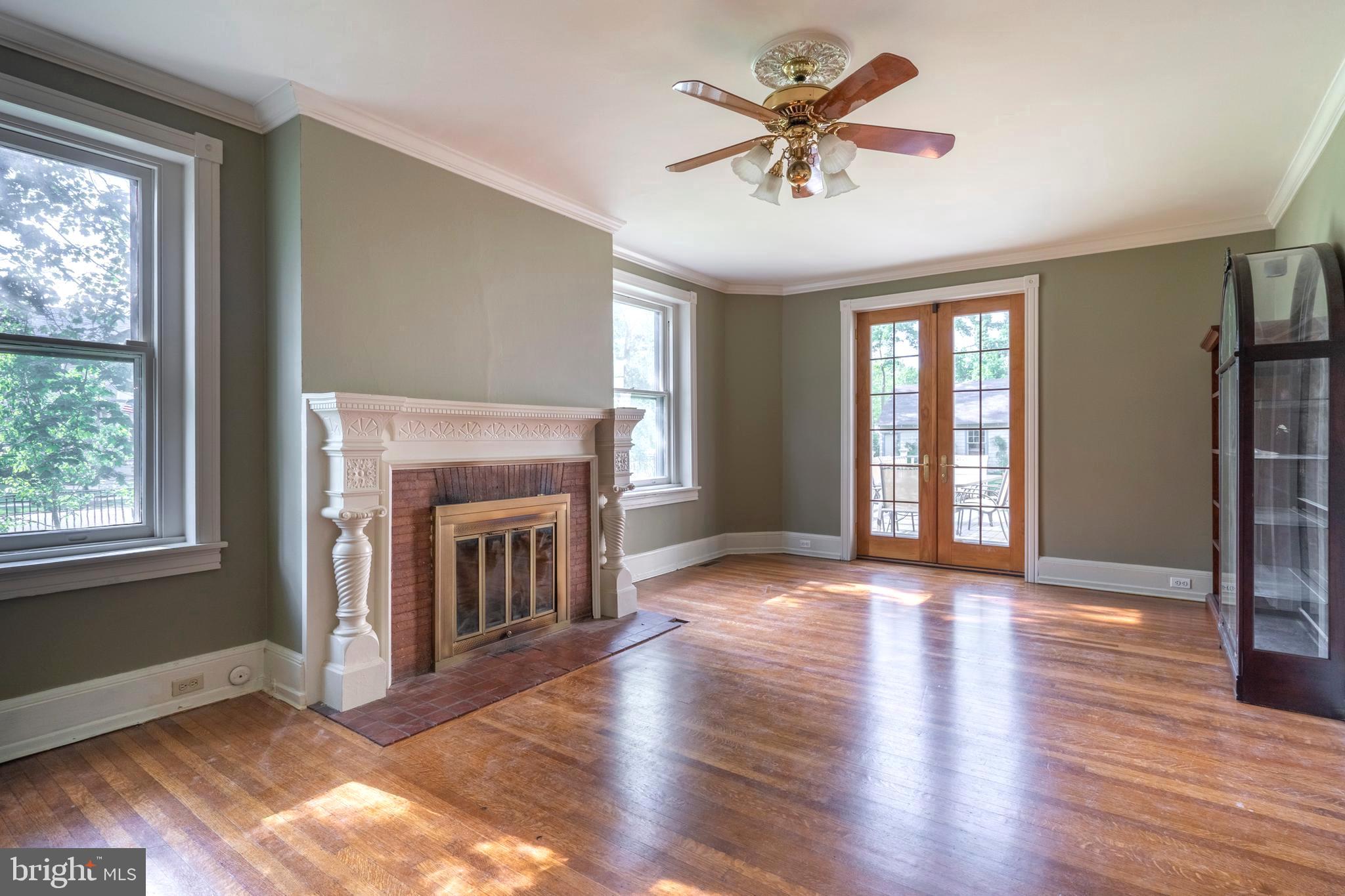 301 Midland Avenue Wayne, PA 19087 - Photo 9 of 63 an empty room with windows fireplace and a kitchen view