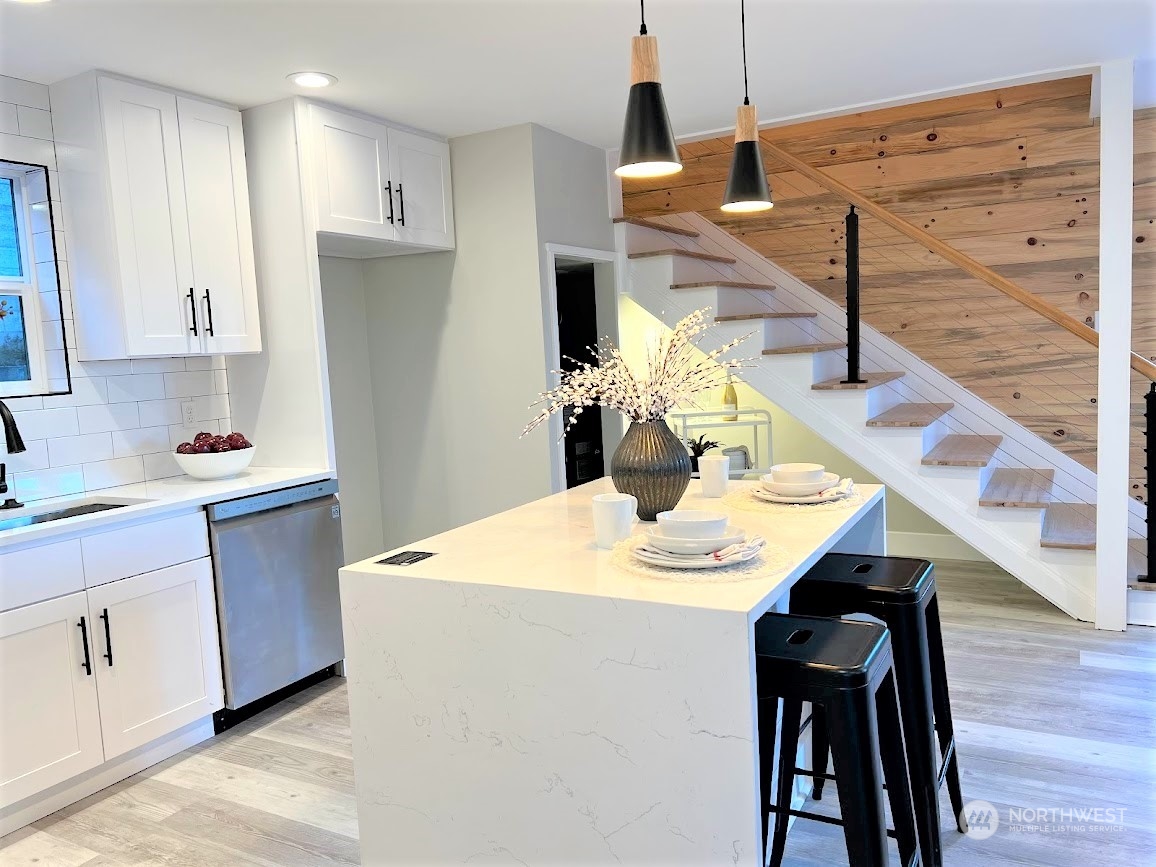 3303 31st Avenue Southwest, Unit B Seattle, WA 98126 - Photo 11 of 26 a kitchen with stainless steel appliances kitchen island wooden floors and wooden cabinets