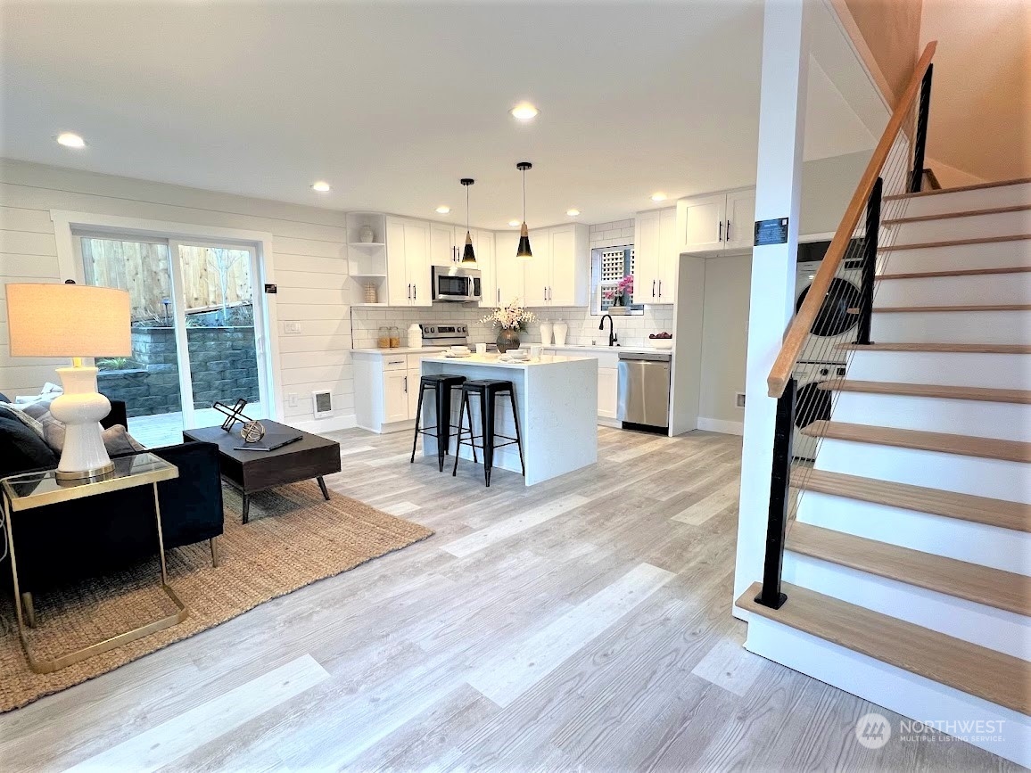 3303 31st Avenue Southwest, Unit B Seattle, WA 98126 - Photo 4 of 26 a living room with stainless steel appliances kitchen island granite countertop furniture wooden floor and a large window