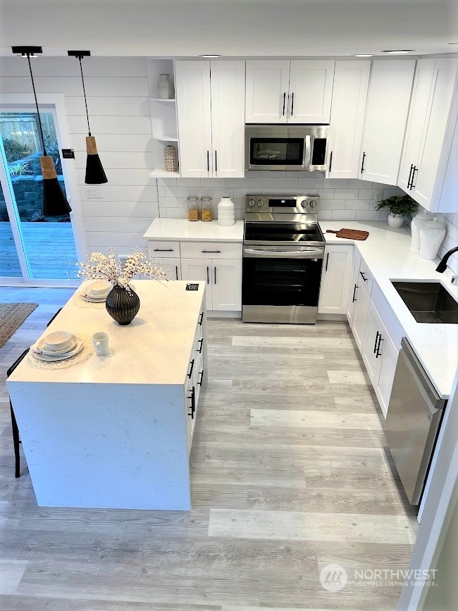 3303 31st Avenue Southwest, Unit B Seattle, WA 98126 - Photo 8 of 26 a kitchen with stainless steel appliances granite countertop a sink a stove and a microwave