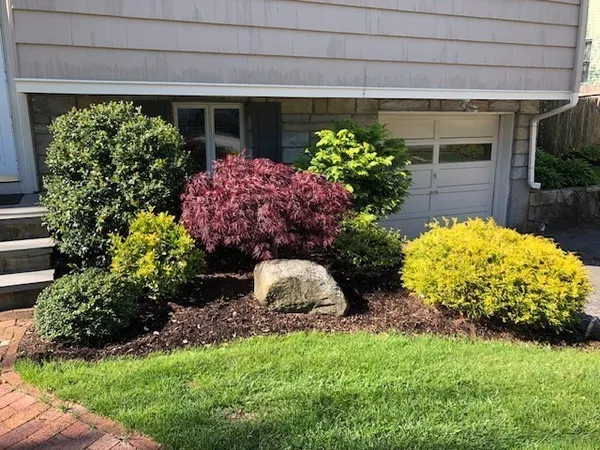 a bunch of flowers in front of yellow house