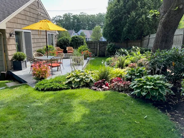 a view of a house with a big yard and potted plants