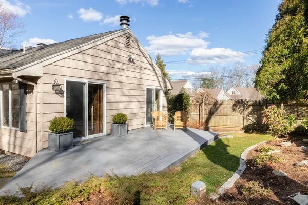 a view of backyard with wheel chair potted plants and floor to ceiling window