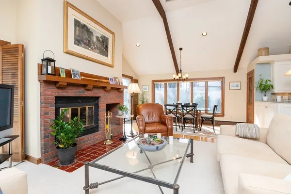 a living room with furniture a large window and a fireplace
