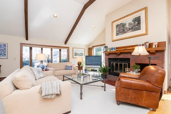 a living room with furniture a fireplace and a large window