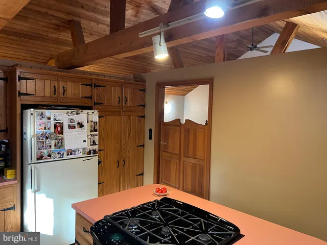 a kitchen with a stove a refrigerator and a window