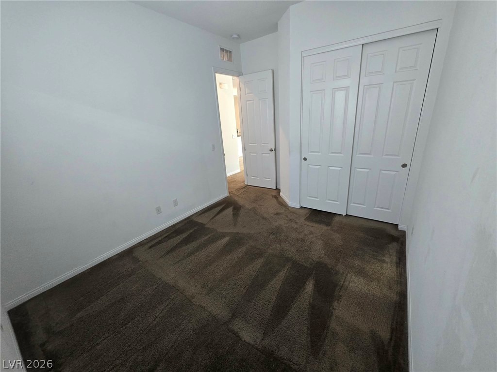 4748 Ritual Street North Las Vegas, NV 89031 - Photo 25 of 31 A well-maintained carpeted floor extends across this peaceful bedroom, offering a serene personal haven.