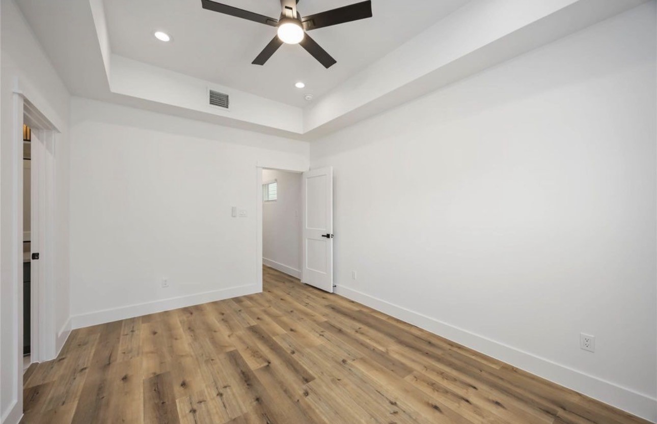 8011 Cora Street, Unit A Houston, TX 77088 - Photo 9 of 14 an empty room with wooden floor fan and windows