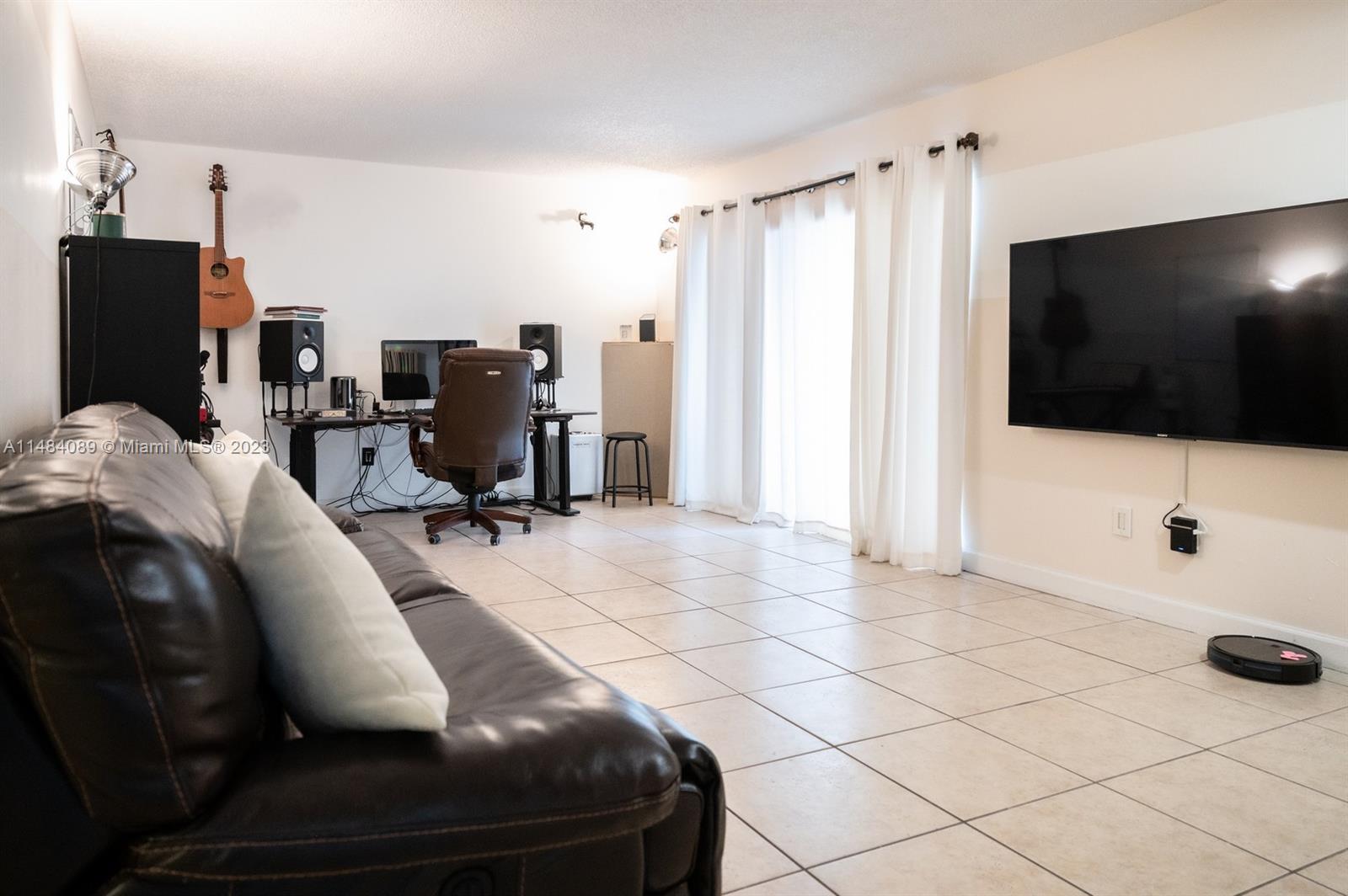 7715 Southwest 86th Street, Unit A2307 Miami, FL 33143 - Photo 14 of 89 a room with furniture and a flat screen tv