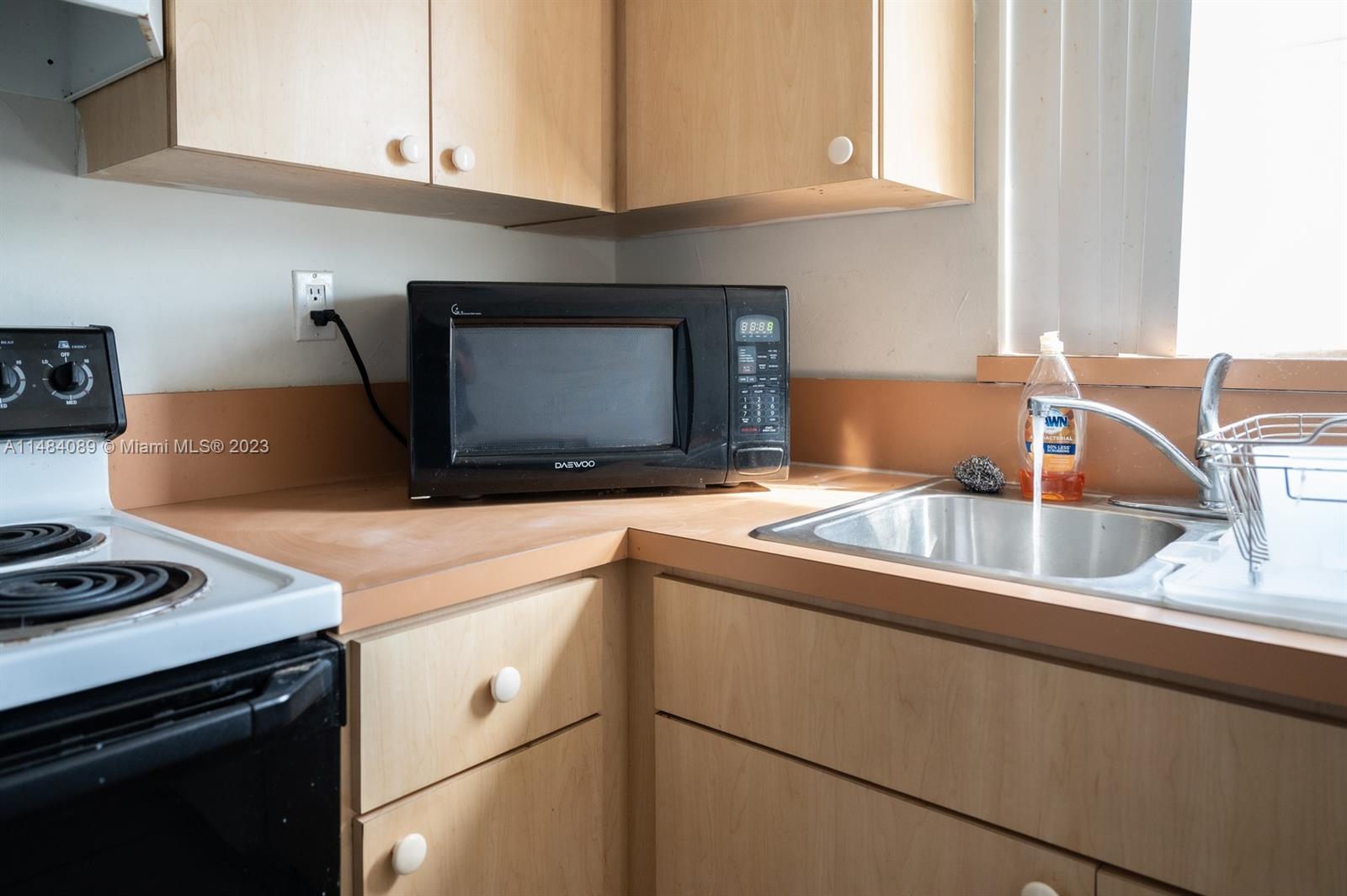7715 Southwest 86th Street, Unit A2307 Miami, FL 33143 - Photo 28 of 89 a kitchen with granite countertop a sink and a stove