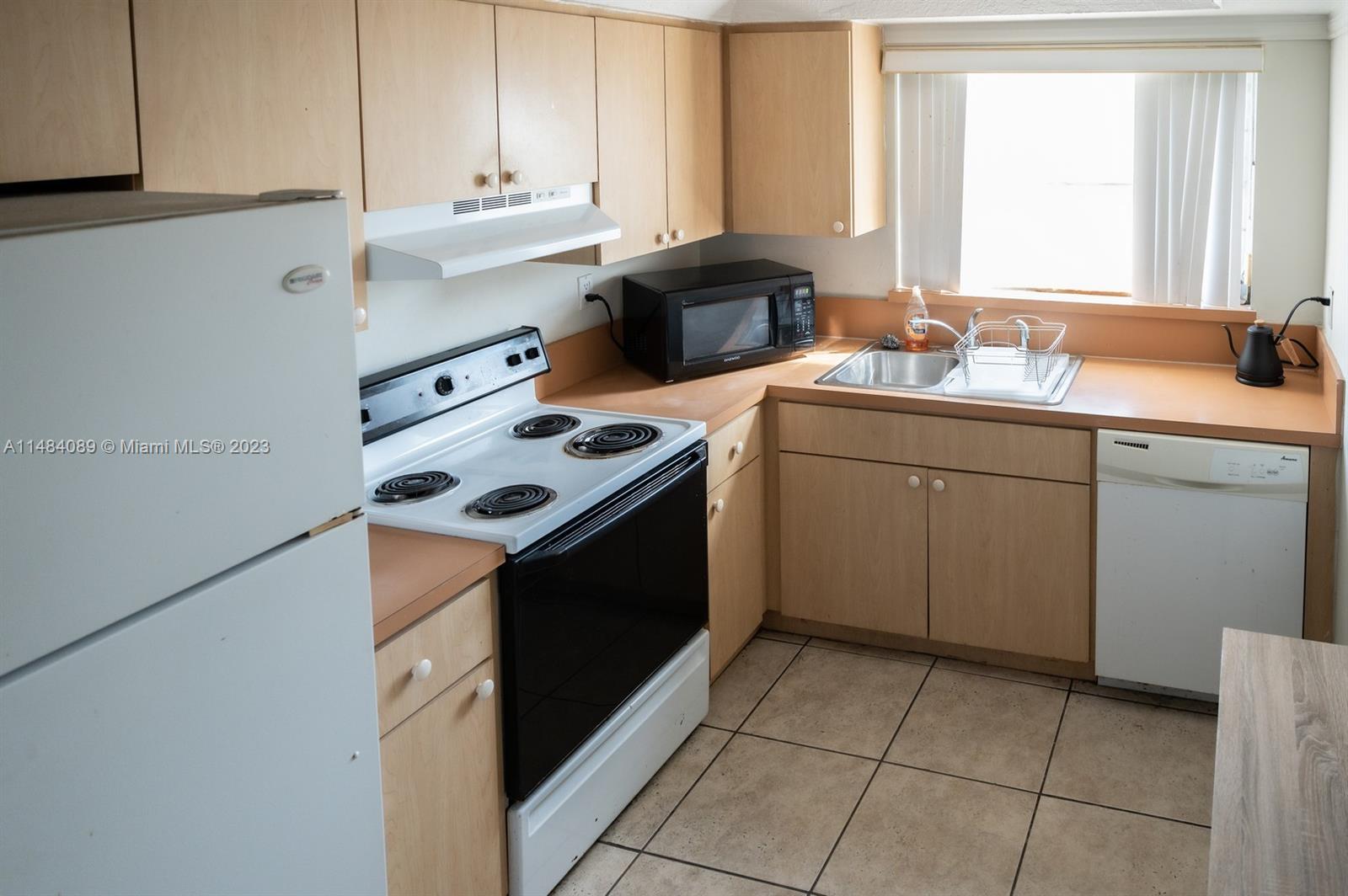 7715 Southwest 86th Street, Unit A2307 Miami, FL 33143 - Photo 29 of 89 a kitchen with a stove sink and cabinets