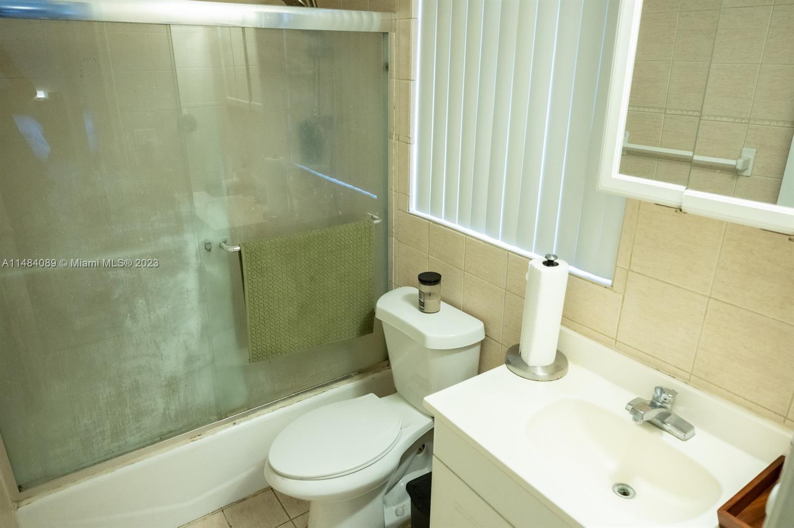 7715 Southwest 86th Street, Unit A2307 Miami, FL 33143 - Photo 36 of 89 a bathroom with a sink a toilet and shower