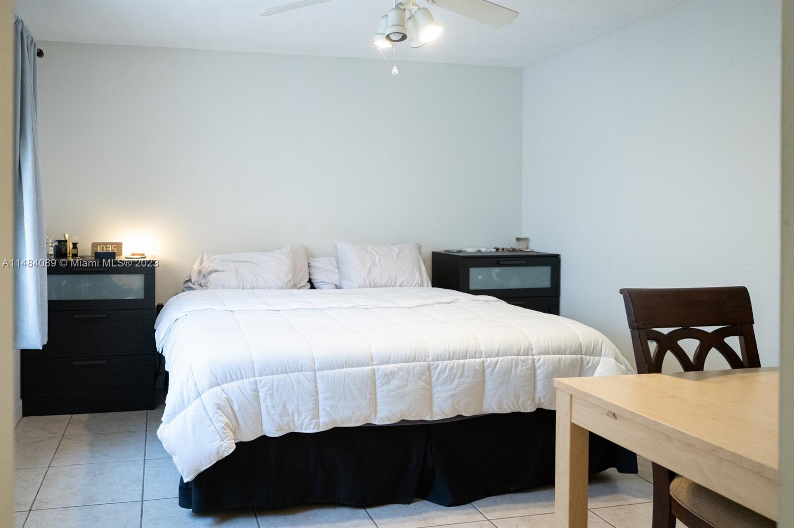 7715 Southwest 86th Street, Unit A2307 Miami, FL 33143 - Photo 46 of 89 a bedroom with a bed and a table