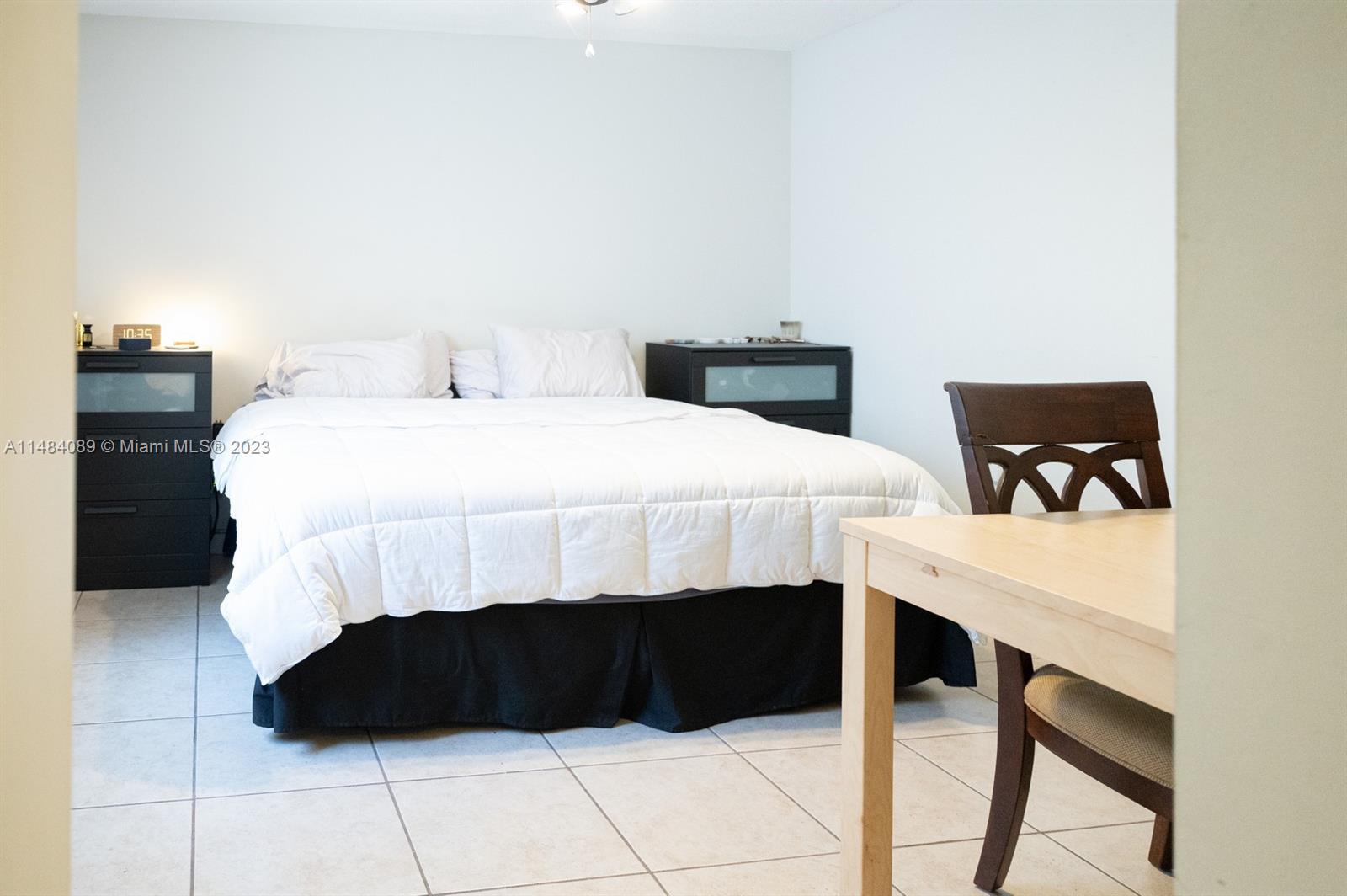 7715 Southwest 86th Street, Unit A2307 Miami, FL 33143 - Photo 48 of 89 a bedroom with a bed a table and a desk