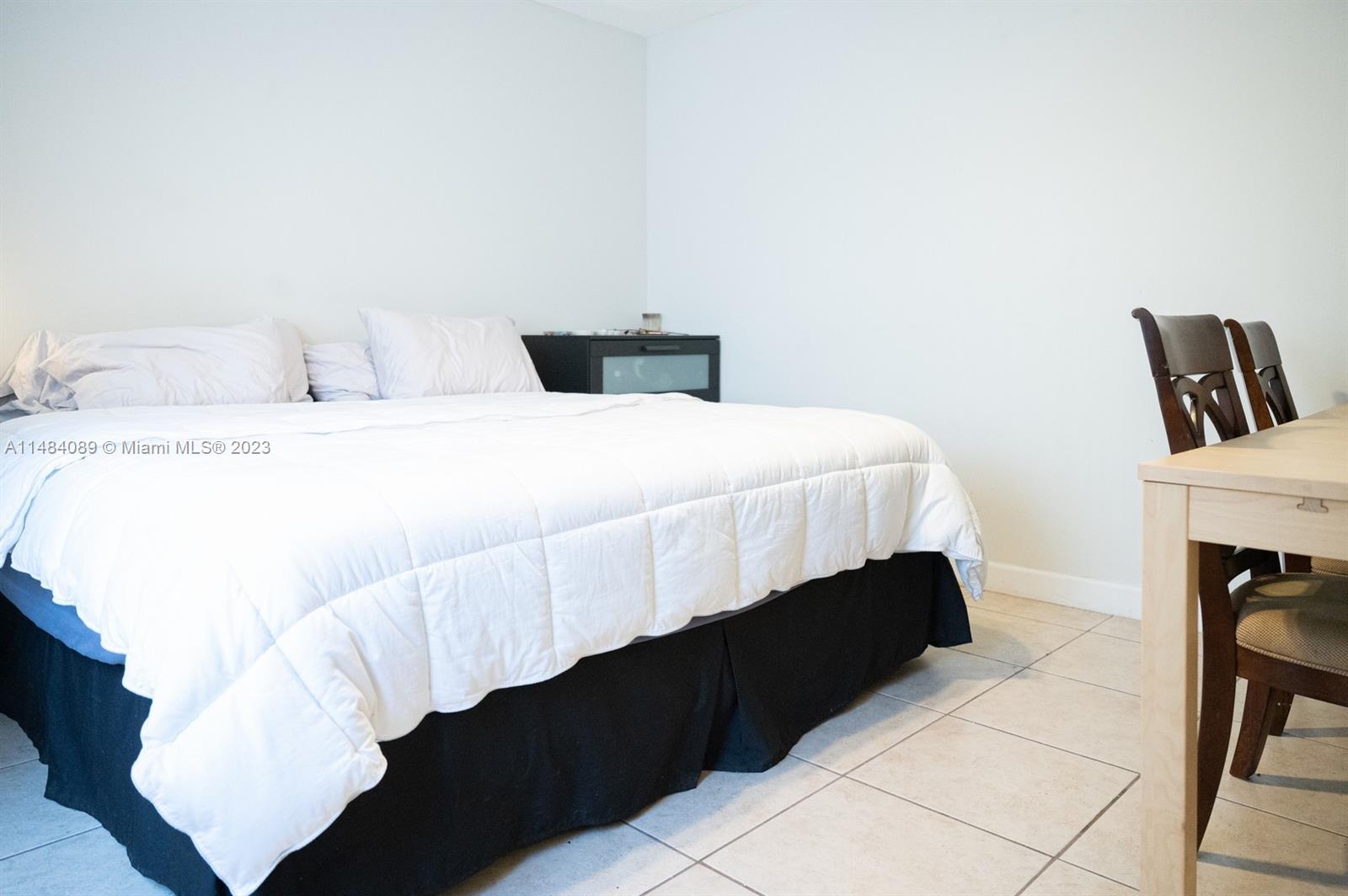 7715 Southwest 86th Street, Unit A2307 Miami, FL 33143 - Photo 49 of 89 a bedroom with a bed and a table