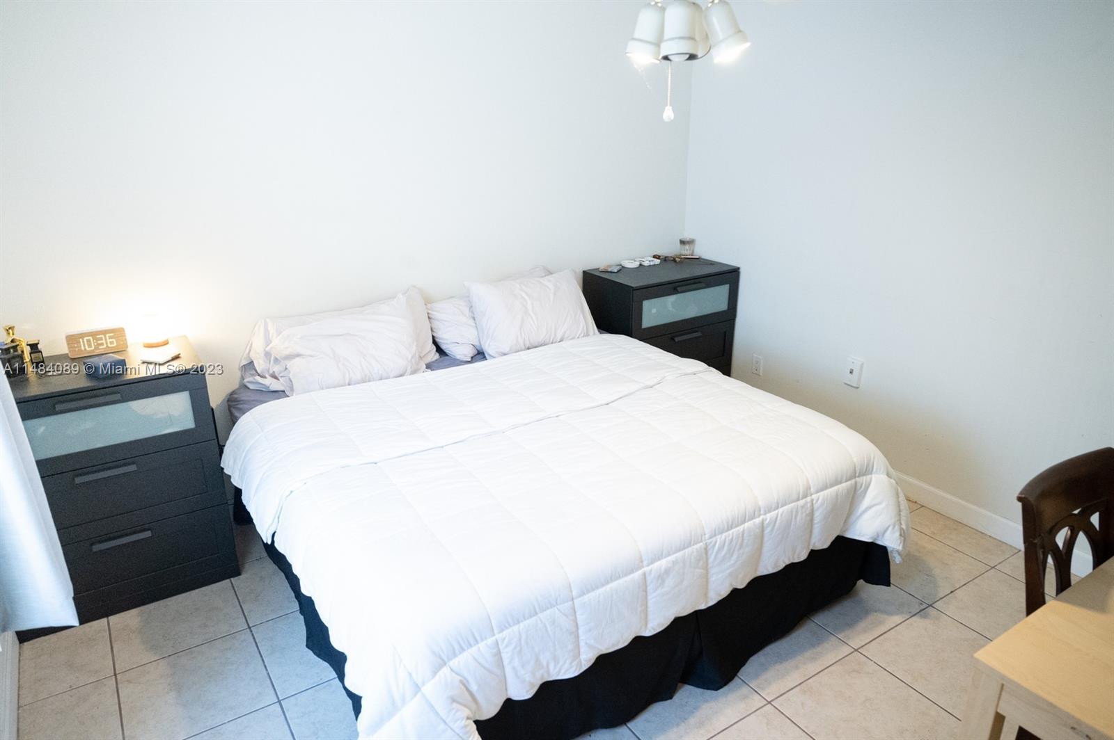 7715 Southwest 86th Street, Unit A2307 Miami, FL 33143 - Photo 51 of 89 a bedroom with a bed and a chandelier