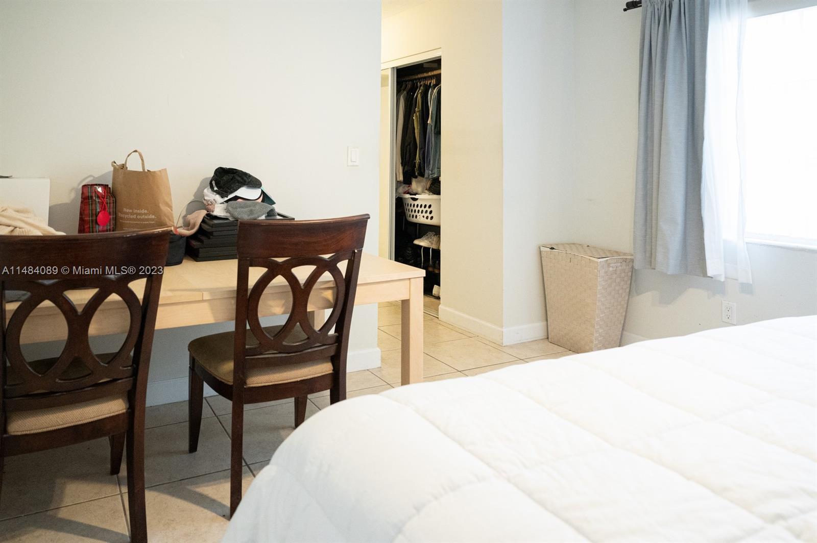 7715 Southwest 86th Street, Unit A2307 Miami, FL 33143 - Photo 54 of 89 a bedroom with a bed and a table with chair
