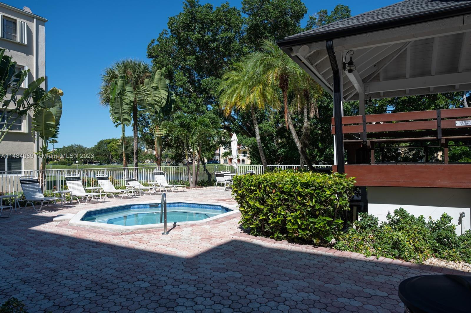 7715 Southwest 86th Street, Unit A2307 Miami, FL 33143 - Photo 82 of 89 a swimming pool with outdoor seating and yard