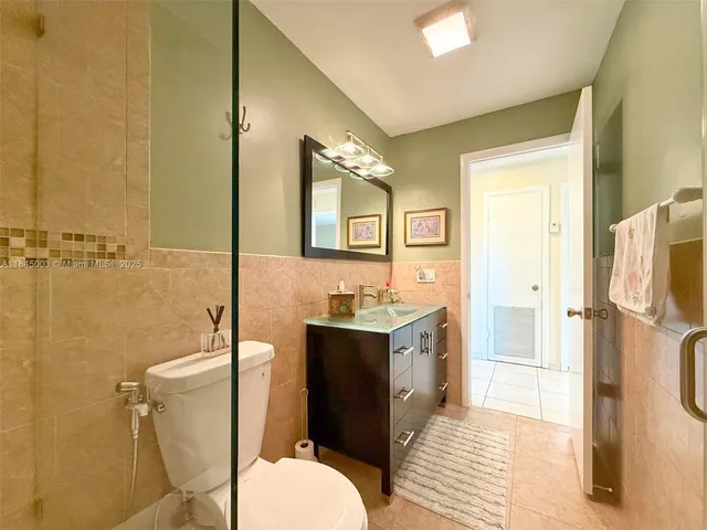 a spacious bathroom with a granite countertop toilet sink and mirror