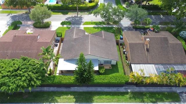 an aerial view of a house with a yard and a swimming pool